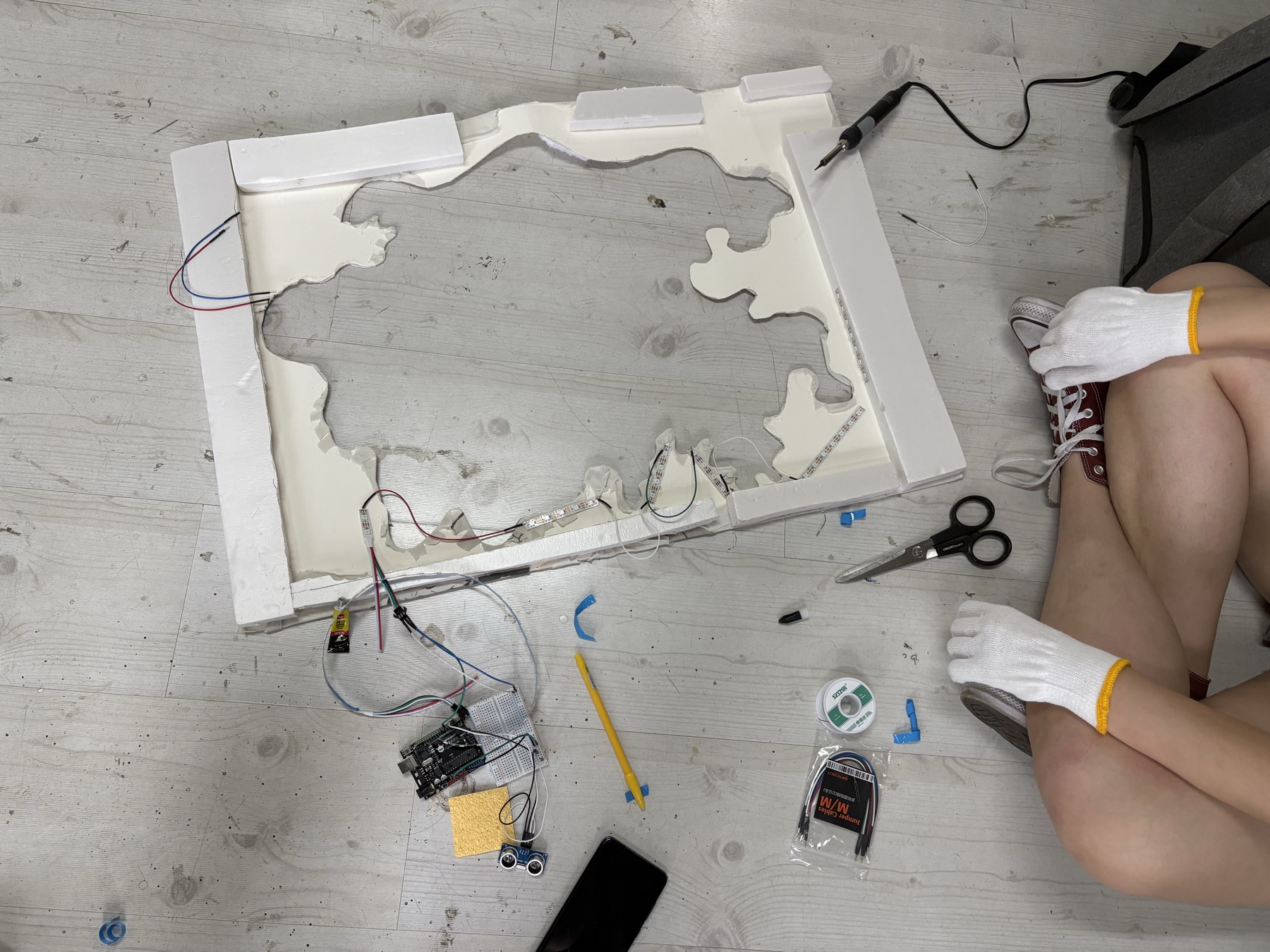 Students testing materials and mechanical movement around a studio worktable